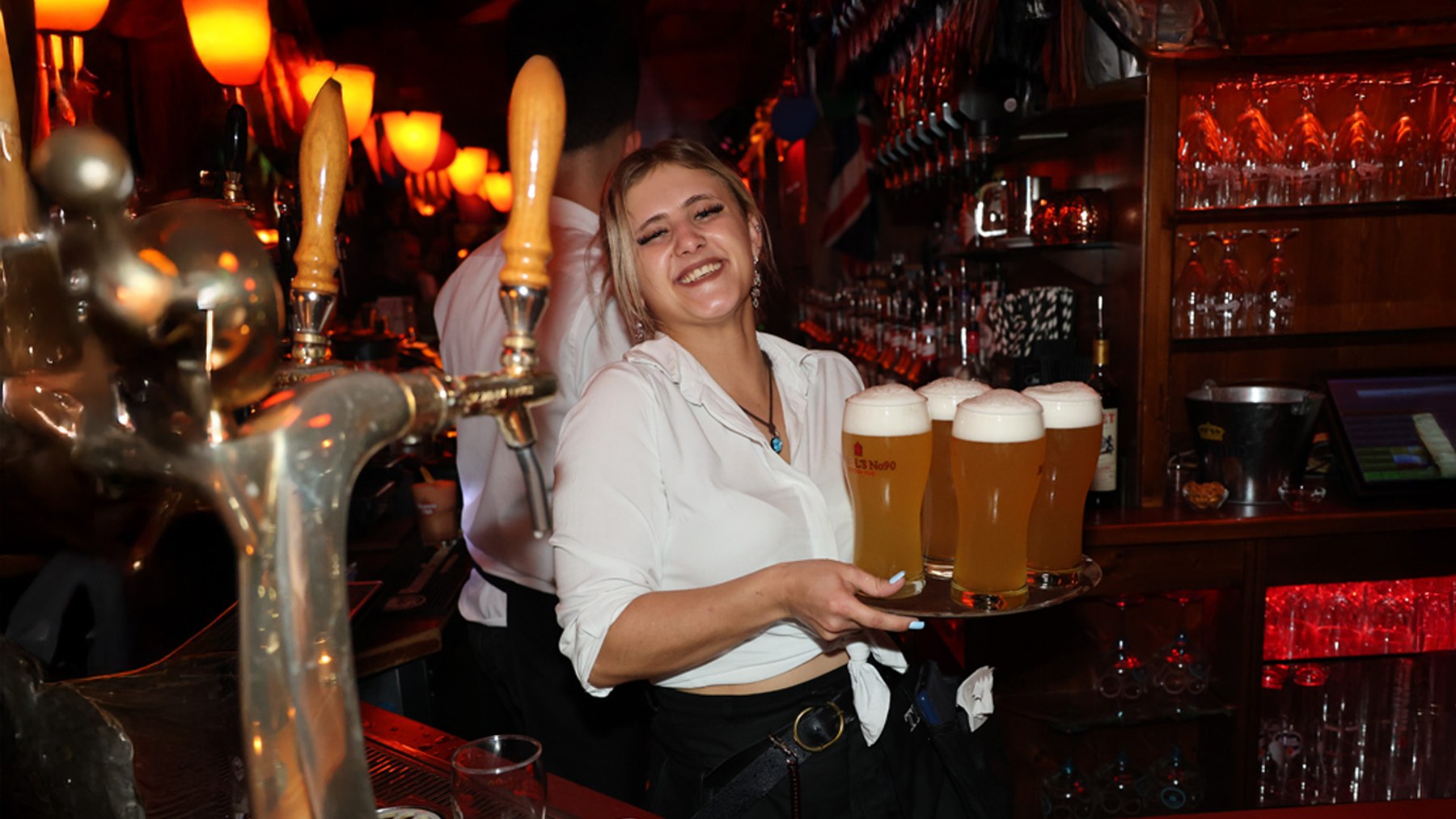 Mitarbeiterin serviert frisch gezapfte Biere an der Bar im MABEL'S